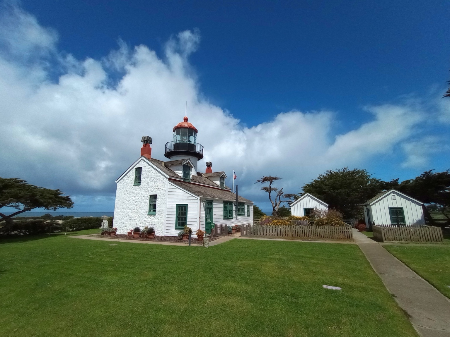 Point Pinos Lighthouse after restoration, with its red lantern dome, photographed from the grounds in April 2026
